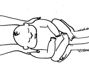 A baby is passed from a woman's hands to a man's hands.